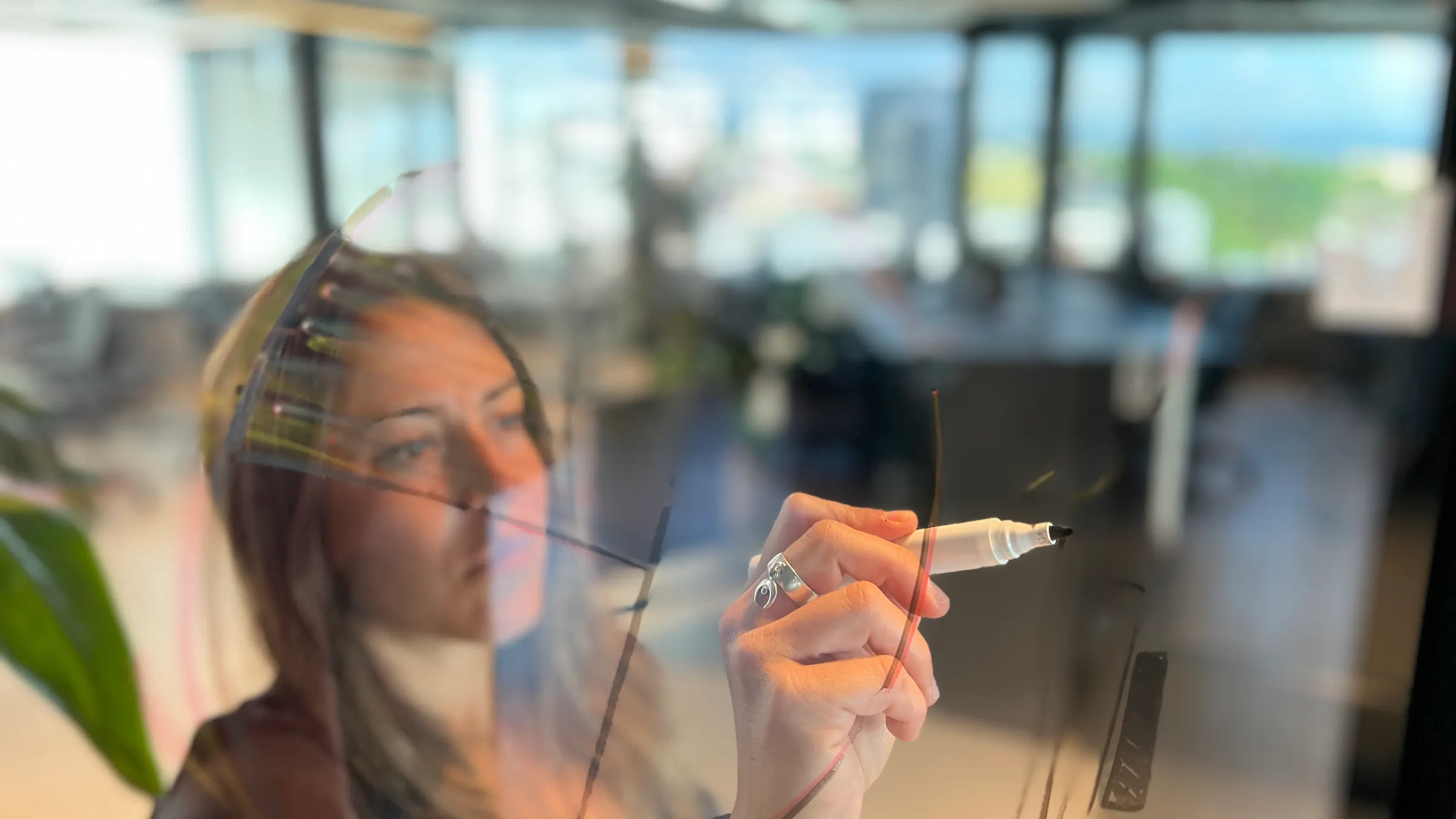 Writing on a glass wall at a Tinkr workshop: the photo at the top of “Hva gjør vi” on tinkr.no.